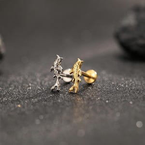 May include: Two stud earrings featuring a koi fish design. One earring is finished in a metallic silver tone, while the other is finished in a metallic gold tone. Each earring has a straight post and a flat circular backing for secure placement.