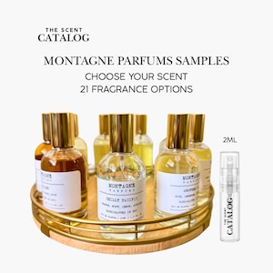 May include: A collection of Montagne Parfums samples in clear glass bottles with gold caps, displayed on a gold-toned tray. The text reads "Choose Your Scent, 21 Fragrance Options." A 2ml sample spray bottle is also included.