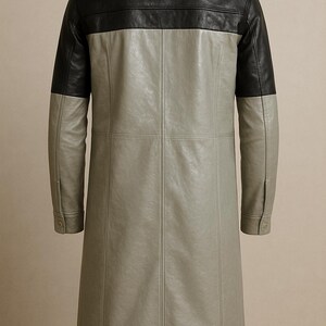 May include: A long, two-tone leather coat. The top yoke and sleeves are black, while the body is a light gray. The coat has a classic collar and buttoned cuffs. Vertical seams run down the front and back, adding structure to the design.