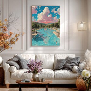 May include: A framed art print depicting a serene outdoor swimming pool scene under a vibrant sky filled with fluffy pink and white clouds. The artwork hangs above a white sofa in a well-lit living room.