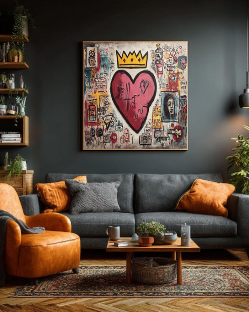 May include: A large framed artwork featuring a red heart with a crown, set against a background of graffiti-style drawings and text. The artwork hangs above a gray sofa with orange pillows, complemented by an orange leather armchair and a wooden coffee table.