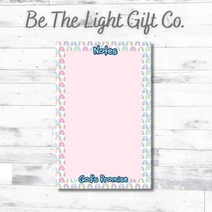 May include: A rectangular notepad with a light pink center and a border featuring a repeating pattern of small, colorful rainbows. The word Notes is printed in blue at the top, and the phrase God's Promise is printed in blue at the bottom.