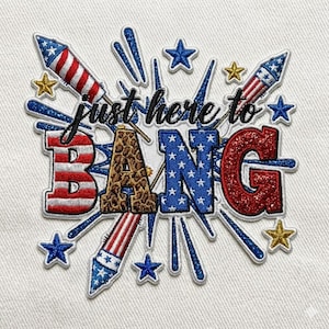 May include: Embroidered patch with the phrase "just here to BANG". The letters are in red, white, blue, and leopard print, with star and firework accents. The patch is designed with a patriotic theme.
