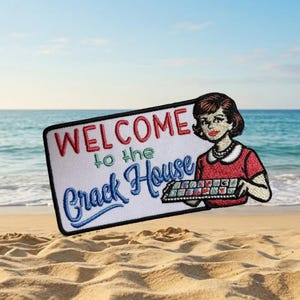 May include: Embroidered patch with the words "WELCOME to the Crack House" in red and blue thread. The patch features a cartoon woman in a red dress and a tray of colorful items. The background is a beach scene.