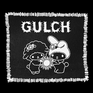 May include: Black square patch with white stitched border. The word "GULCH" is at the top in a distressed font. Two cartoon characters are holding a sun. The patch is black with white line art.