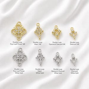 May include: A collection of eight jewelry connectors in gold and white gold tones, featuring four-leaf flower, heart, openwork diamond, and diamond shapes. Each piece includes double loops and small clear stones, labeled with their specific design names.