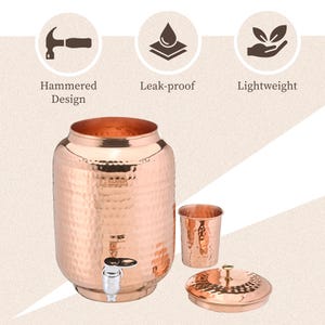 Puede incluir: Un dispensador de agua de cobre con un diseño martillado, un grifo y una taza y tapa a juego. El dispensador es a prueba de fugas y ligero. La imagen también muestra las palabras "Hammered Design", "Leak-proof" y "Lightweight".