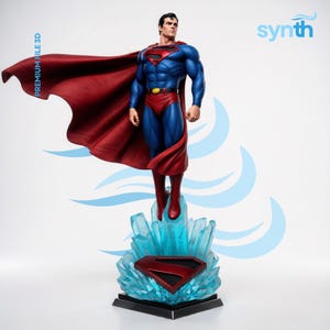May include: A Superman statue in a classic pose, wearing a blue suit, red trunks, and boots, with a flowing red cape. The statue stands on a blue crystal base with the Superman logo. The words "PREMIUM FILE 3D" and "synth" are visible.