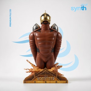 Puede incluir: Estatua marrón de The Rocketeer, un personaje retro-futurista. La estatua presenta un casco dorado, mochilas propulsoras plateadas y un mono marrón. La base dice "The Rocketeer" en letras doradas. La imagen también incluye el texto "PREMIUM FILE 3D" y el logo synth.