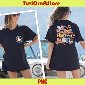 Può includere: T-shirt nero con la scritta "SEE THE ABLE NOT THE LABEL" sul retro e una piccola grafica sul davanti. La grafica anteriore include un simbolo di pace, fiori e la scritta "SEE THE ABLE NOT THE LABEL".