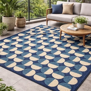 Könnte beinhalten: Ein blauer Outdoor-Teppich mit einem geometrischen Muster aus Halbkreisen in Blau- und Cremetönen. Der Teppich ist rechteckig und liegt auf einer gefliesten Terrasse, mit einem Sofa und einem Couchtisch im Hintergrund.