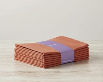 Set di 100 tovaglioli riutilizzabili in cotone biologico color arancio ruggine, morbidi e lavabili, ideali per matrimoni.