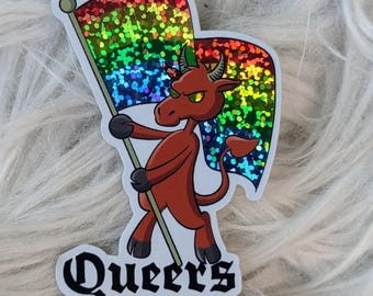 May include: A sticker depicting a cartoon devil with a rainbow flag. The devil is red with horns and a tail. The sticker has the text "Queers for Satan" in a gothic font, with the artist's Instagram handle below.