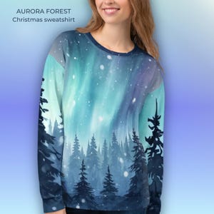May include: A crew neck sweatshirt featuring a winter forest scene with an aurora borealis design. The text "AURORA FOREST Christmas sweatshirt" is printed at the top. The design includes shades of blue, green, and white.