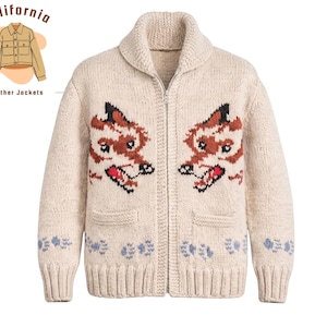 Puede incluir: Cárdigan con cremallera de color crema con cuello chal y dos bolsillos delanteros. El suéter presenta un diseño bordado detallado de dos caras de zorro de dibujos animados en marrón, negro y rojo. El dobladillo inferior tiene un patrón repetido azul y blanco. El texto "California leather Jackets" está en la esquina superior izquierda.