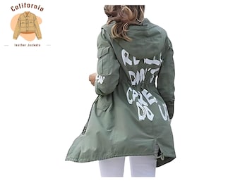 Könnte beinhalten: Olivgrüne Kapuzenjacke mit weißem Text auf dem Rücken: „REALLY DON'T CARE DO U“. Die Jacke hat Taschen und einen Kordelzug in der Taille. Teil der California Lederjacken-Kollektion.