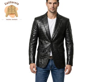 Könnte beinhalten: Ein schwarzer Lederblazer mit geprägtem Krokodilmuster. Der Blazer hat einen Zwei-Knopf-Verschluss, eine fallendes Revers und zwei Vordertaschen. Das Model trägt eine blaue Jeans und ein weißes T-Shirt. Das California Leather Jackets Logo ist sichtbar.