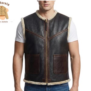 Op de afbeelding: Een zwarte leren vest met bruine randen en een crèmekleurige voering van schapenvacht. Het vest heeft een ritssluiting, twee voorzakken en een logo "California leather jackets".