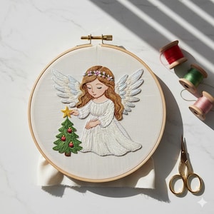 May include: Embroidered angel hoop art featuring a serene angel with flowing brown hair, a floral crown, and white wings. The angel is placing a star on a green Christmas tree adorned with red ornaments. The artwork is set in a wooden hoop.