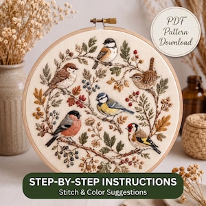 Op de afbeelding: Een borduurring met crèmekleurige stof en een gedetailleerd geborduurd ontwerp van vijf vogels op takken met bladeren en bessen. De afbeelding bevat de tekst PDF Pattern Download en Step-by-Step Instructions.