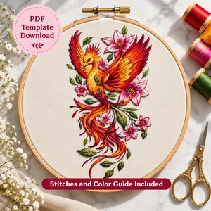 Puede incluir: Un bastidor de bordado circular de madera que contiene un panel de tela con un diseño detallado de un fénix y flores en tonos rojos, naranjas y rosas. El texto PDF Template Download y Stitches and Color Guide Included es visible.