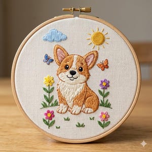 Puede incluir: Obra de arte bordada con un perro corgi sonriente en un prado soleado. El diseño incluye una nube azul, un sol amarillo, flores coloridas y mariposas. La obra está enmarcada en un bastidor de bordado de madera.