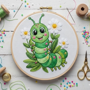 May include: A hand-stitched embroidery hoop featuring a smiling green caterpillar with white daisies and green leaves. The embroidery is set in a wooden hoop. Sewing supplies, including thread spools, needles, and scissors, are arranged around the hoop.