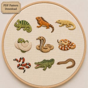 Può includere: Un telaio da ricamo contenente un pannello in tessuto beige con nove disegni di rettili ricamati, tra cui un camaleonte verde, un'iguana arancione, una lucertola gialla, un piccolo verde, un cobra, un serpente a strisce, un serpente corallo, un coccodrillo e un serpente marrone. Il testo recita PDF Pattern Download.