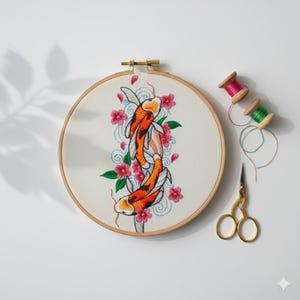 Peut inclure: Broderie d'art représentant des carpes koï dans un cercle de bois. L'œuvre présente deux carpes koï orange et blanches nageant parmi des fleurs roses et des tourbillons d'eau bleus. Avec des bobines de fil et des ciseaux dorés.