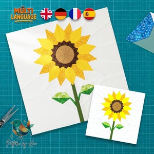 Pode incluir: Um quadrado branco com um grande desenho de girassol amarelo, com um centro castanho e caule e folhas verdes. Uma versão menor do girassol está abaixo. A imagem tem o texto "MULTI LANGUAGE" e um logotipo que diz "Pattern by Kia".