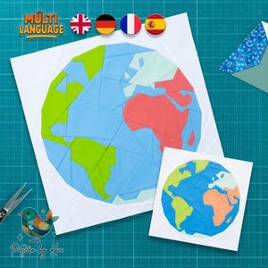 May include: A paper craft project featuring two globe designs constructed from geometric shapes in blue, green, and coral colours on white square backgrounds. The larger globe shows continents, while the smaller one is a simplified version.
