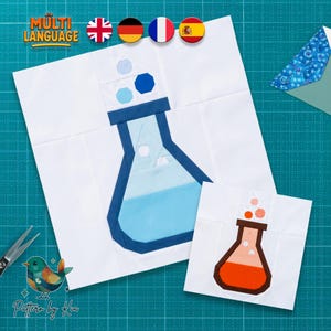 May include: Two square fabric quilt blocks featuring a science flask design. One block displays a large blue flask with light blue liquid and bubbles on a white background. The second smaller block shows a brown flask with orange liquid and bubbles.