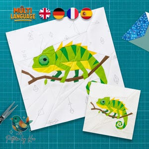 Puede incluir: Dos cuadrados de tela blanca con un diseño de camaleón verde y amarillo sobre una rama marrón. El cuadrado más grande tiene un fondo de patrón geométrico. La imagen incluye el texto "MULTI LANGUAGE" y banderas.