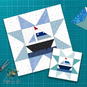 May include: Two nautical-themed quilt blocks. The larger block features a sailboat design with a red and white striped sail and a blue and white star-patterned sail. The smaller block has a similar design. Both are set against a white background with blue accents.