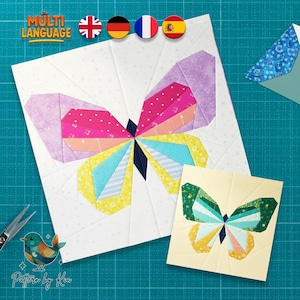 Könnte beinhalten: Zwei farbenfrohe Schmetterlings-Quiltblöcke. Der größere Block zeigt einen Schmetterling mit rosa, lila, gelben und blauen Flügeln auf weißem Hintergrund. Ein kleinerer Block zeigt einen grün-gelben Schmetterling. Das Bild enthält den Text "MULTI LANGUAGE" und "Pattern by Kia".