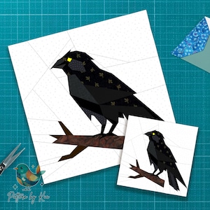 May include: Two paper craft designs of a black crow perched on a branch, with yellow eyes and a patterned wing. The designs are on white backgrounds with a grid pattern. The larger design is approximately 8 inches by 8 inches.