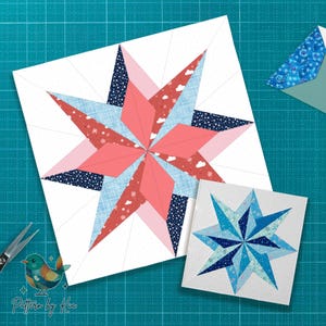 May include: Two star-shaped quilt blocks, one large and one small, with a variety of fabrics. The larger block features coral, light blue, and navy fabrics. The smaller block is shades of blue. A pair of scissors and a patterned envelope are also visible.