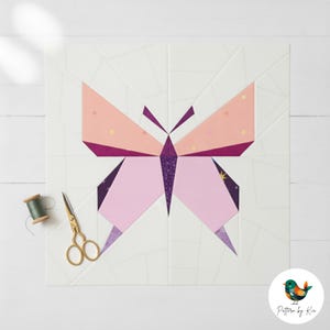 Op de afbeelding: Een geometrisch vlinderquiltblok in roze, paarse en perziktinten, tegen een witte achtergrond. Gouden schaar en een spoel groen garen staan links. Het ontwerp is een moderne interpretatie van een klassiek quiltpatroon.