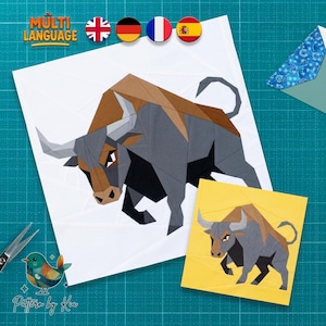 Puede incluir: Un patrón de manualidades con una ilustración geométrica de un toro en tonos grises y marrones. El diseño se presenta en una hoja cuadrada blanca y una hoja cuadrada amarilla más pequeña, junto a unas tijeras y un gráfico de un pájaro.