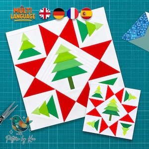 Op de afbeelding: Twee vierkante quiltblokken van stof met een centraal groen kerstboomontwerp omringd door rode driehoeken op een witte achtergrond. De bomen zijn opgebouwd uit gelaagde tinten groene stof en de blokken zijn gerangschikt op een raster.