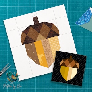 Pode incluir: Um design de bolota em patchwork em papel quadriculado branco, com tecidos castanhos, bege e amarelos. Um design de bolota semelhante menor está em um fundo preto. A imagem inclui tesouras e um logotipo de pássaro padronizado com o texto "Pattern by Kia."