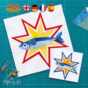 Könnte beinhalten: Ein Quilt-Block-Muster mit einem aus Stoffstücken zusammengesetzten Fisch in der Mitte eines gelben Sterns mit rotem Umriss auf weißem Grund. Eine kleinere Version desselben Fisch- und Stern-Designs befindet sich unten rechts neben dem Hauptblock.