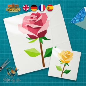 May include: Two origami roses, one pink and one yellow, on white squares. The pink rose is larger and more detailed. Green leaves and brown stems accompany the flowers. The image includes the text "MULTI LANGUAGE" and a logo with the text "Pattern by Kia".