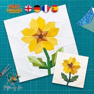 May include: Two white fabric squares with a yellow sunflower design. The larger square has a full sunflower with a green stem and leaves. The smaller square has a miniature version of the same design. The text "MULTI LANGUAGE" is at the top.