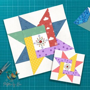 May include: Two colorful quilt blocks with star and floral designs. The larger block features blue, green, red, yellow, and purple fabrics. The smaller block mirrors the design. A pair of scissors and a bird logo are in the image.