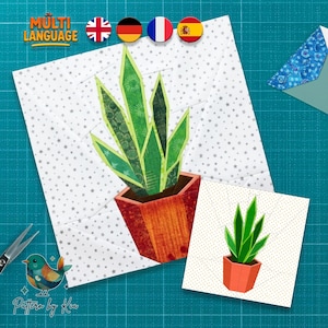 Puede incluir: Una pieza de arte textil con una planta suculenta verde y amarilla en una maceta de terracota. El diseño está sobre un fondo blanco con patrones de estrellas grises. La imagen incluye el texto "MULTI LANGUAGE" y una pequeña ilustración de un pájaro.