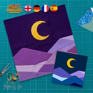 May include: A fabric art piece featuring a crescent moon over mountains in shades of purple and blue. The design includes the text "MULTI LANGUAGE" and flags. A smaller version of the design is also present.