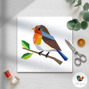 May include: A colorful geometric bird design on a white background. The bird features shades of orange, blue, brown, and yellow, perched on a brown branch with green leaves. The image includes scissors, a button, and spools of thread.