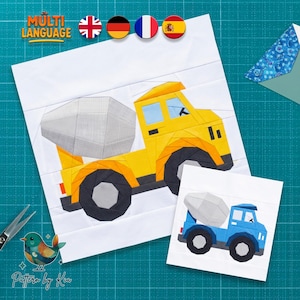 May include: A fabric quilt block pattern featuring a yellow cement mixer truck with a gray drum and black wheels, alongside a smaller version of the same truck in blue. The design is presented on a white background with visible seam lines.