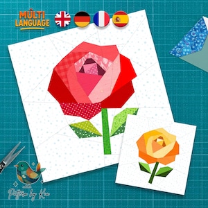 Könnte beinhalten: Zwei Papierschnittmuster von Rosen. Die größere Rose ist rot, rosa und grün, und die kleinere Rose ist orange und grün. Die Muster befinden sich auf weißem Hintergrund mit einer blauen Schneidematte im Hintergrund. Der Text "Multi Language" steht oben.